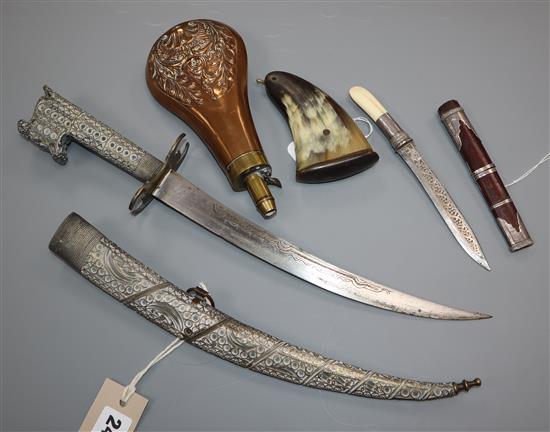 An Eastern plate-mounted dagger with inlaid blade and filigree decoration, a Burmese dha and two powder flasks,